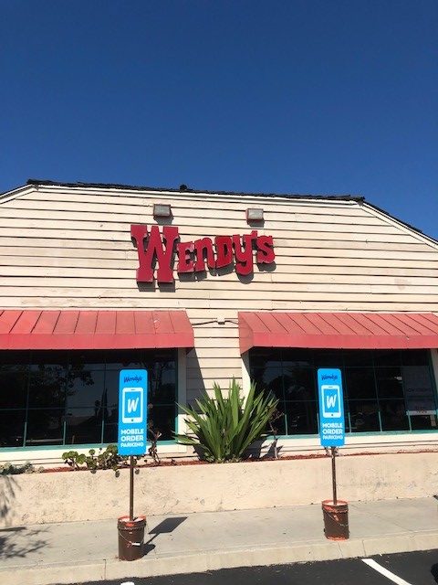 A Wendy's restaurant with parking spots in front for mobile order customers.