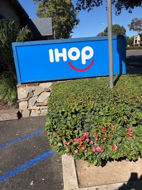 A blue IHOP sign in front of the restaurant.