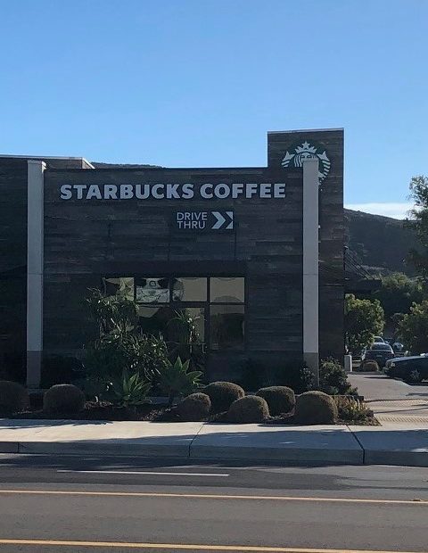 A Starbucks coffee shop with a drive-thru lane.